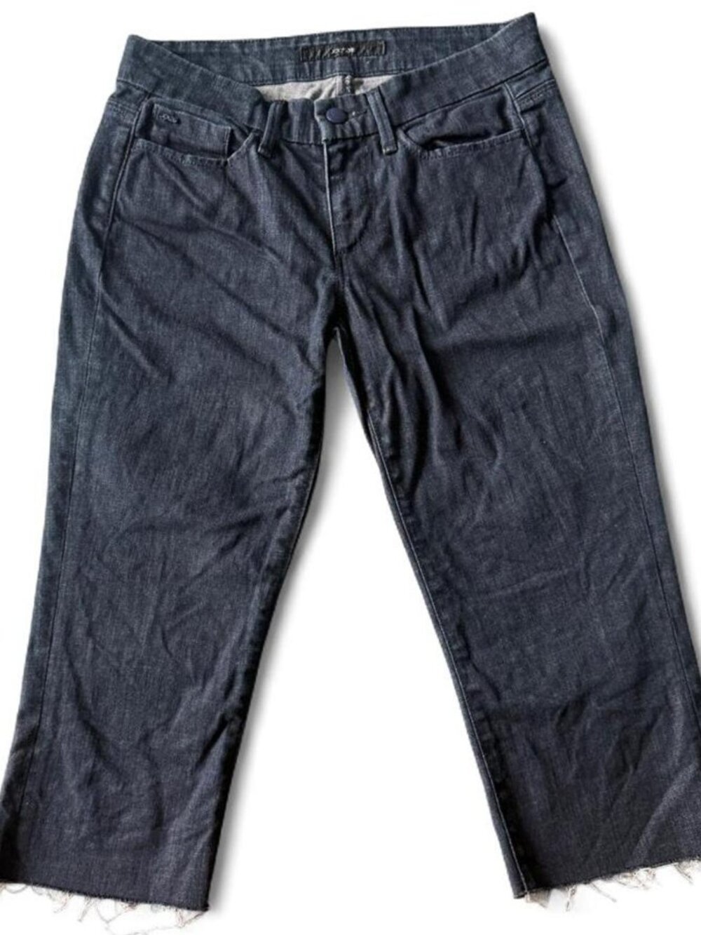 Joe’s dark wash low rise denim capris with raw hem at ankle.